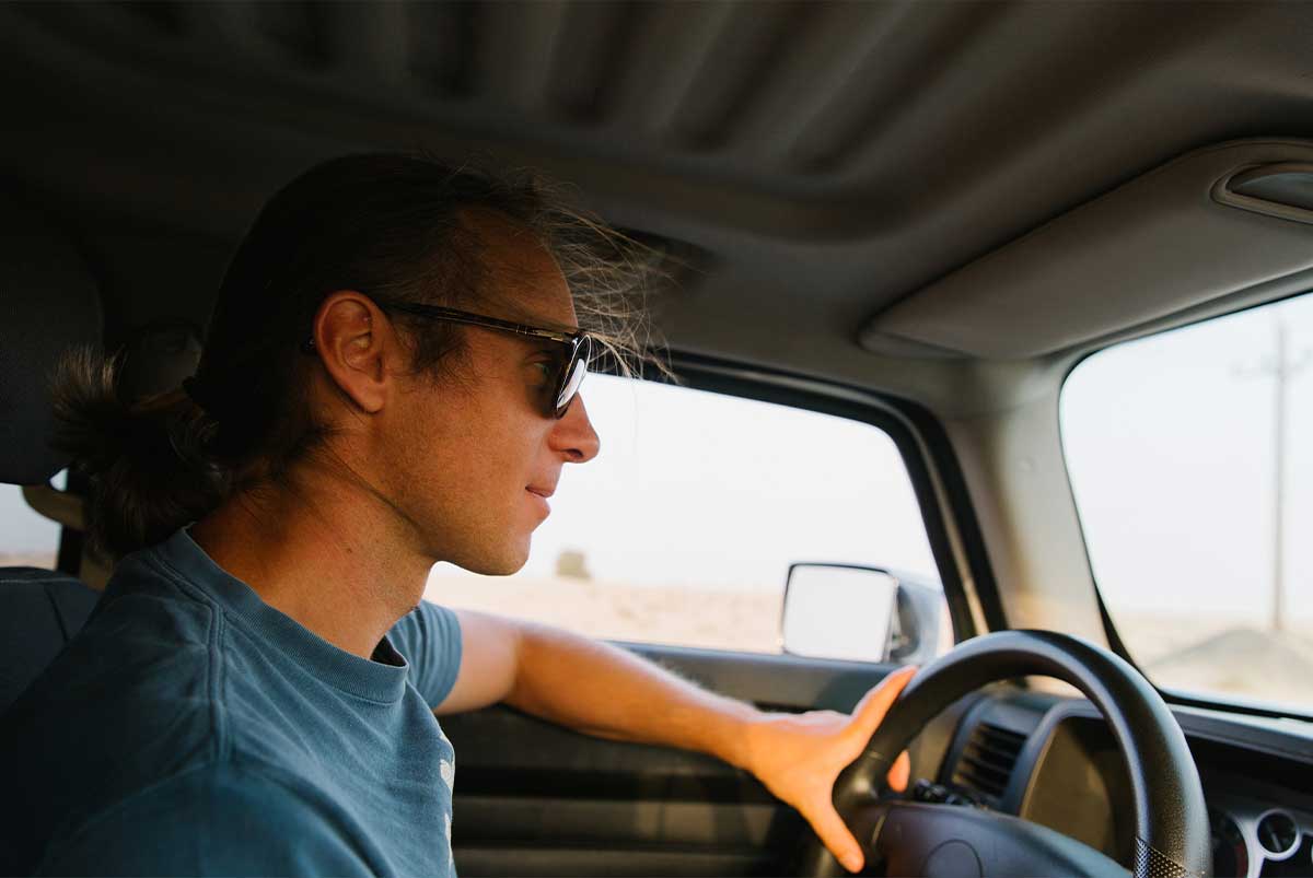 young man behind wheel driving car