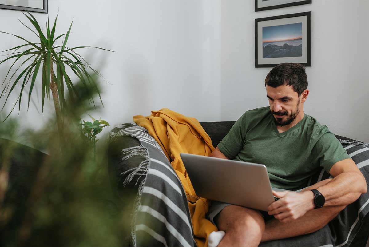 Man sitting on couch with laptop