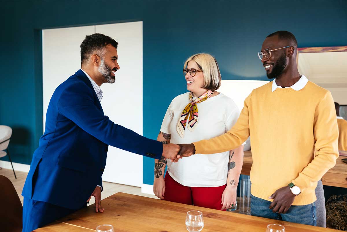 A couple shakes hands with a bank teller