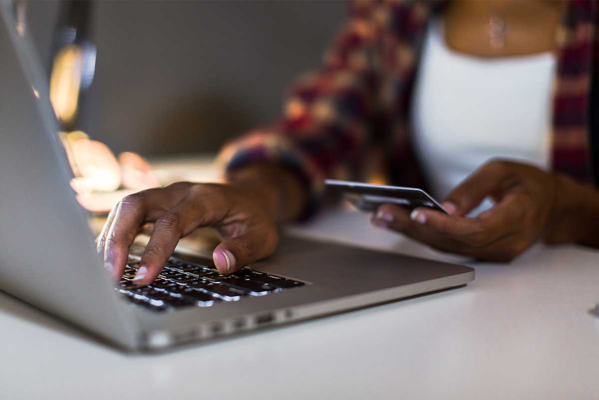 Woman using credit card at computer