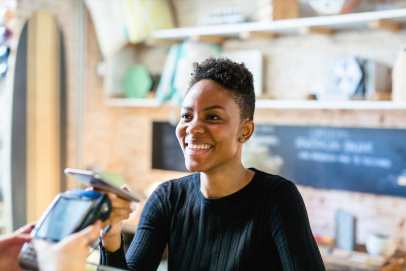 women scanning her phone to pay at register