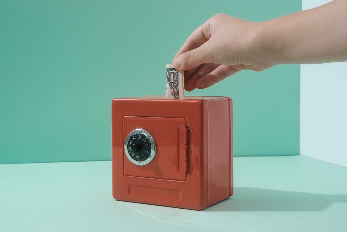 dollar bill being placed into a safe