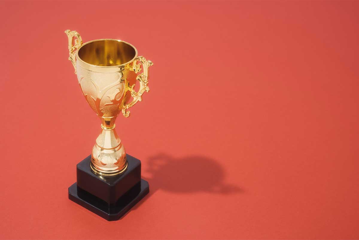 A golden trophy against a dark orange background