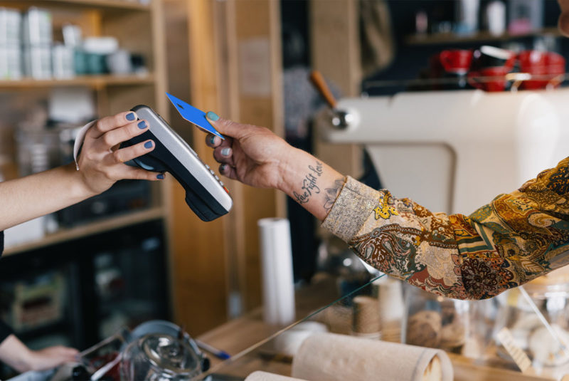 Female customer holding credit card near nfc