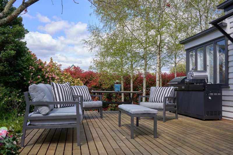 Backyard deck with patio furniture surrounded by trees