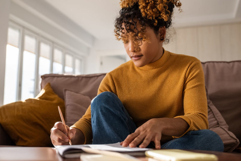 student making notes at table