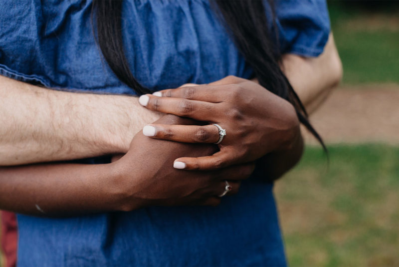 Couple Embracing With Engagement Ring Featured