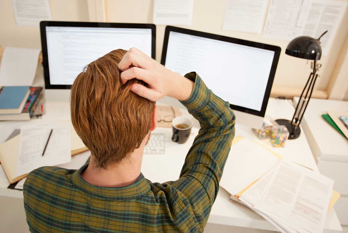 Frustrated person in front of monitors