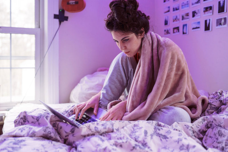 a college student looking at her computer wondering how to repay her student loans