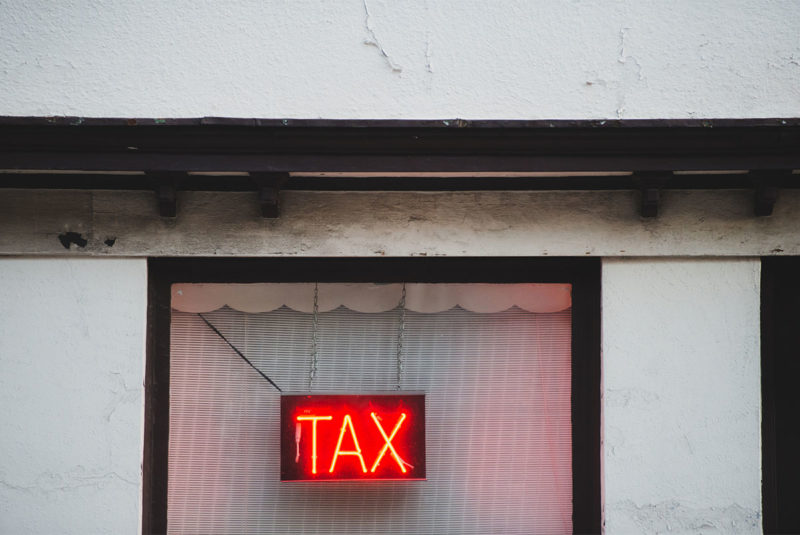 light up sign with words Tax on it