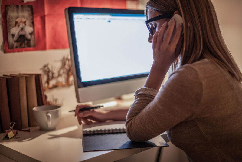 Woman on her phone at a desk