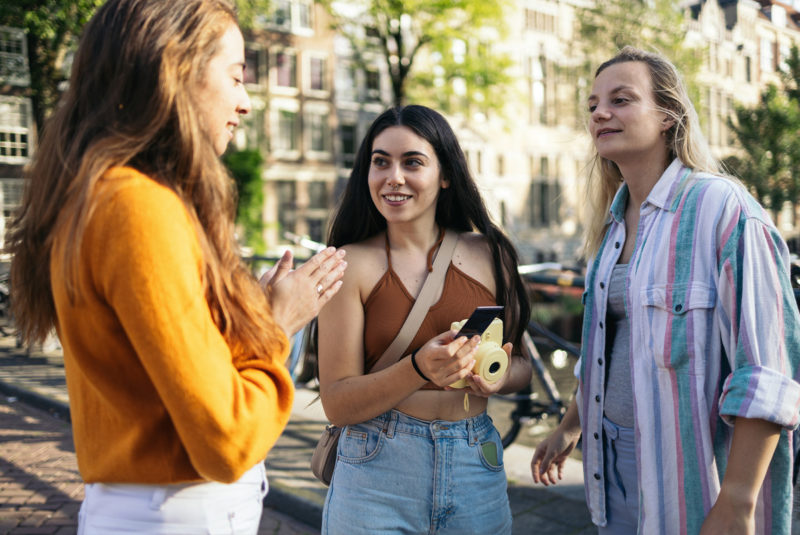 Three students chatting on college campus