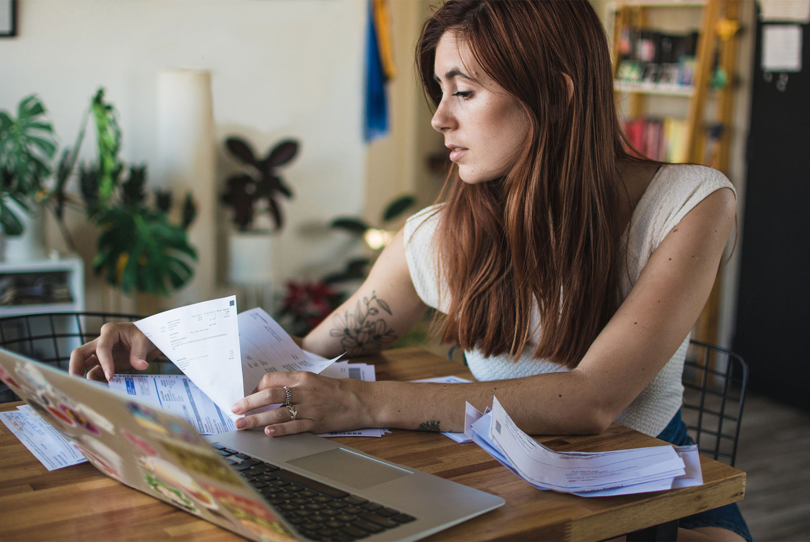 woman choosing a mortgage lender looking through papers and sitting at table