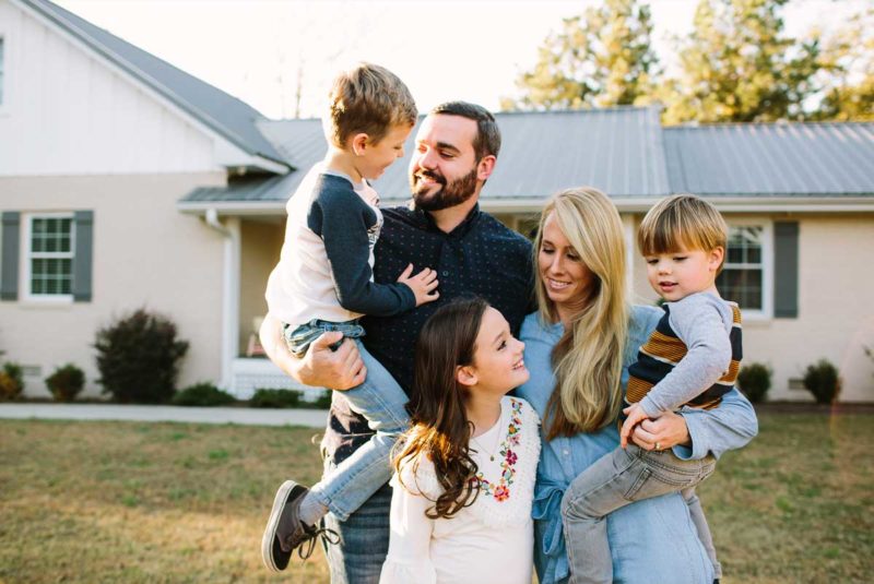 Family standing in front of a house