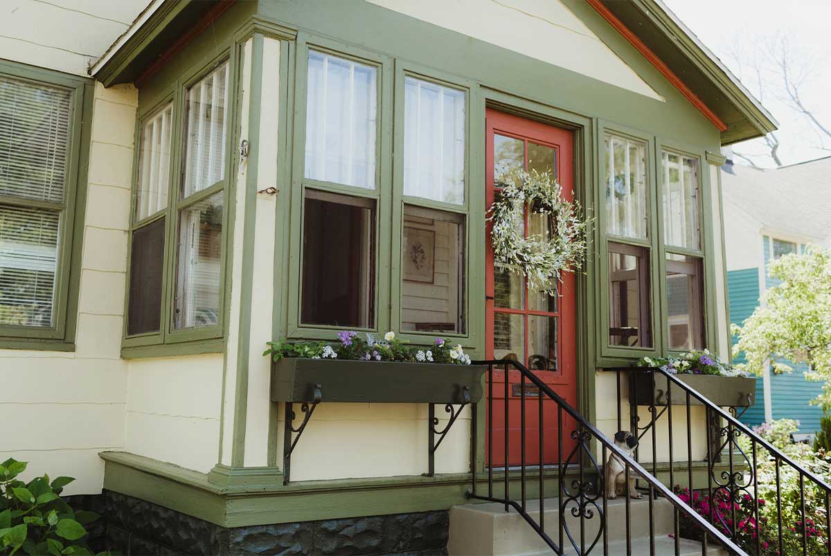 Cute home with a pug sitting on the front steps