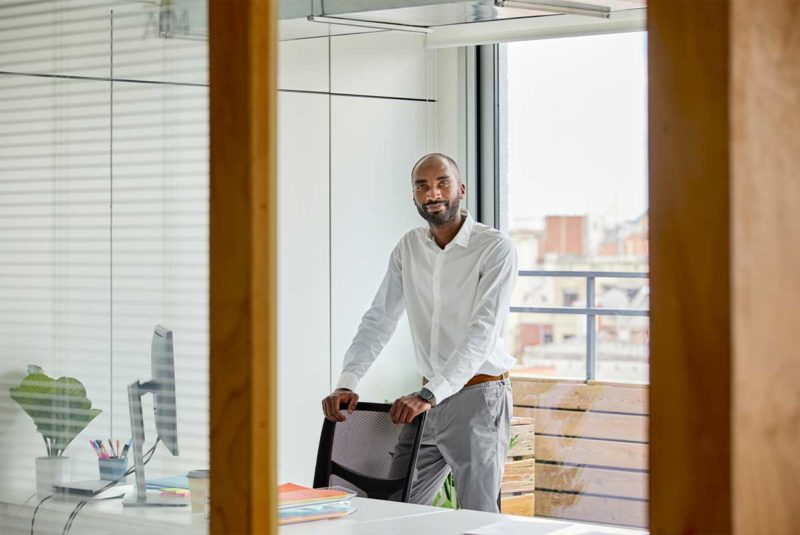 Man in mortgage office offering chair