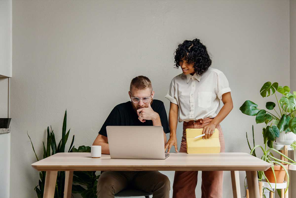 A young couple are looking for houses on a laptop.