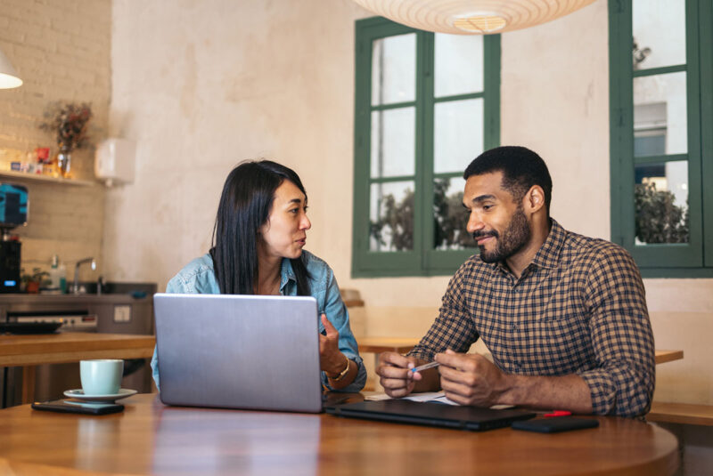 A couple sit and review the personal loan requirements at a laptop.