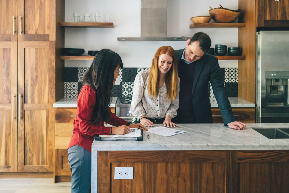 A young couple meets with a real estate agent.