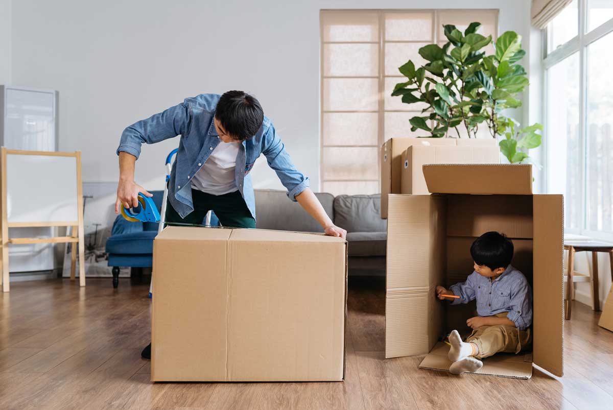 Father and child playing with cardboard boxes