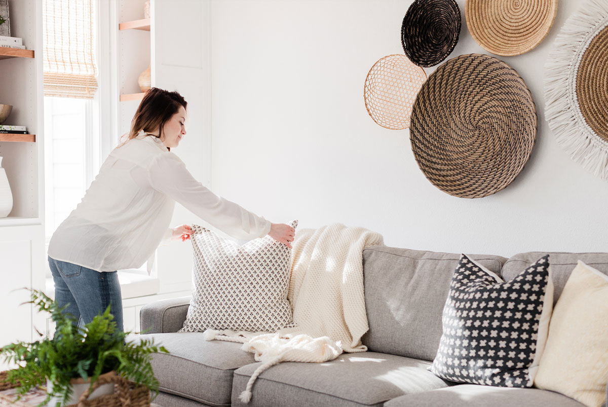 Woman fixing pillows on couch