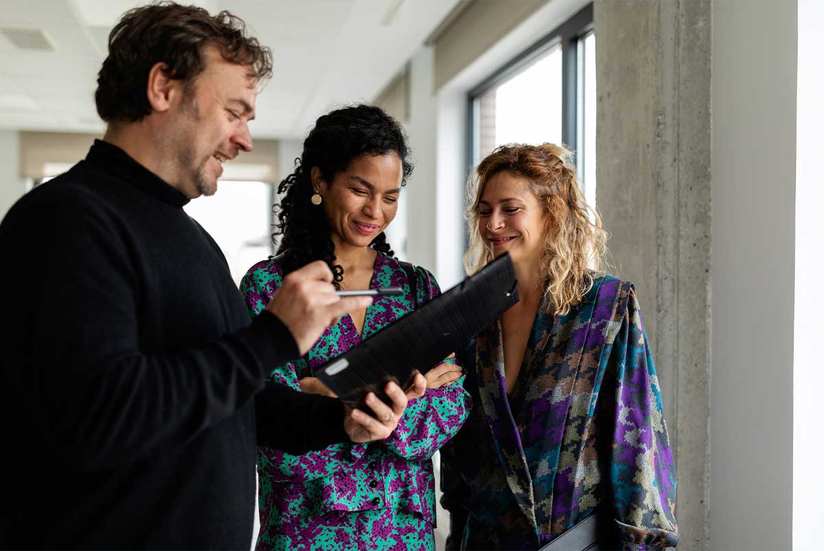 Three people looking at a folder smiling.