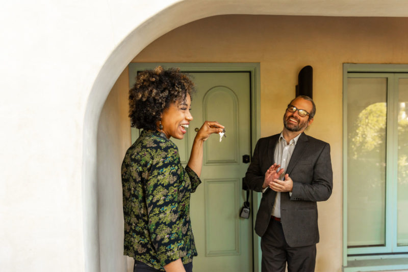 happy lady with keys in her hand having followed a home buying checklist