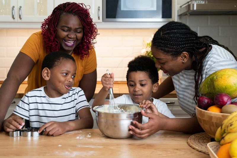 Afircan-American Family with two moms in kitchen.