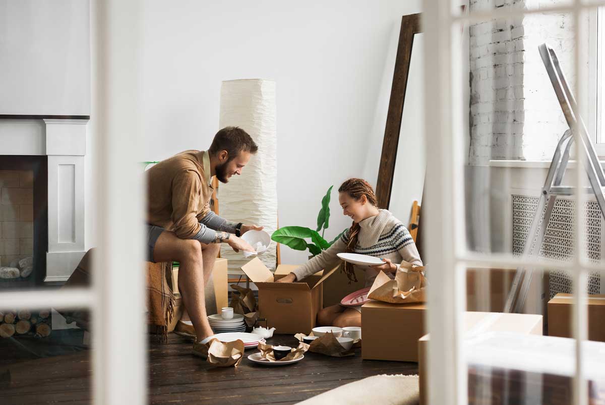 Two people unpacking moving boxes