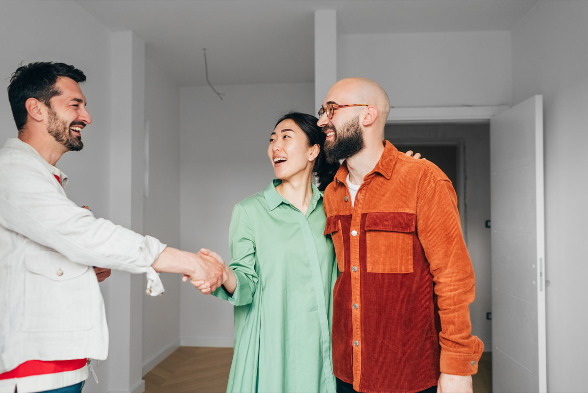 couple shaking hands with another person