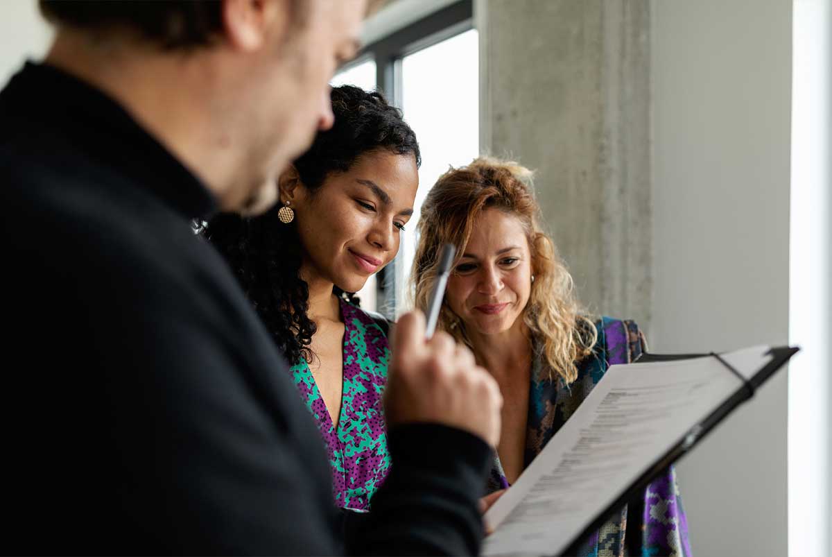 Two women and a man looking at a spec sheet