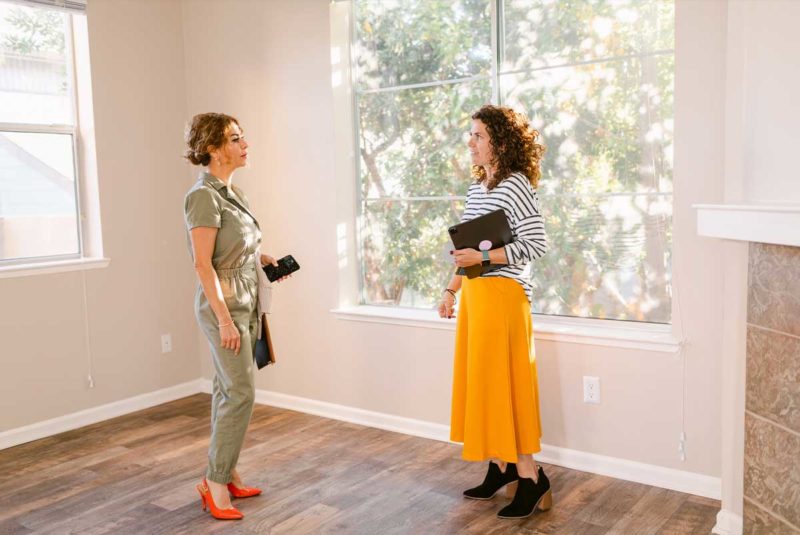 Woman and realtor looking at house