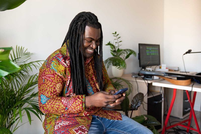 Man smiling while using mobile phone