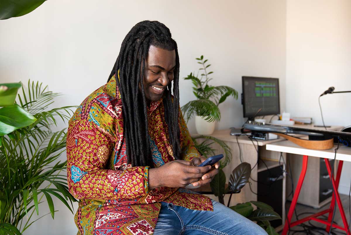 Man smiling while using mobile phone